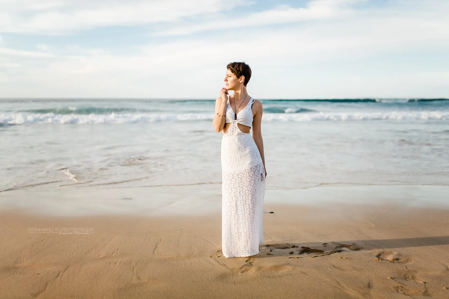 Woman in a long white dress on the beach