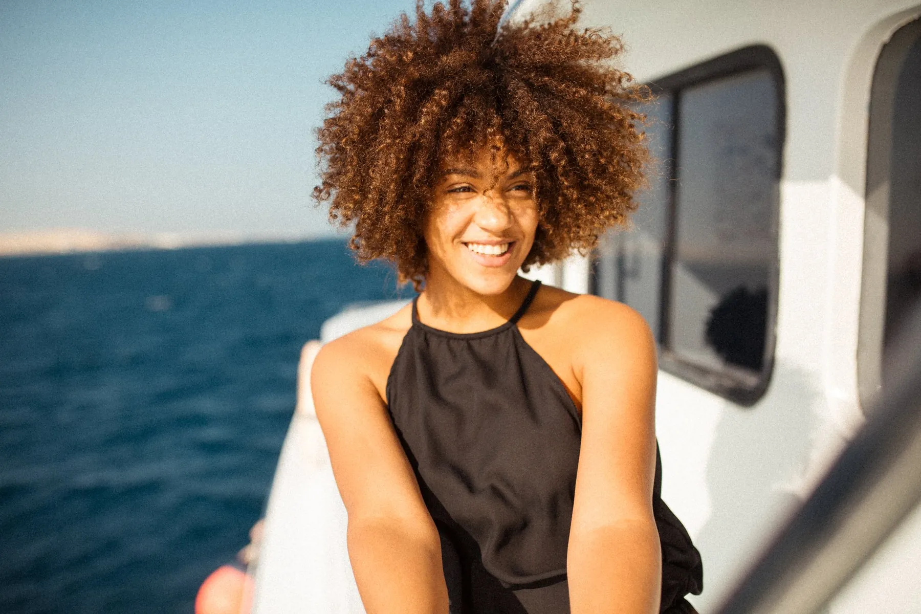 Laughing woman with curls on a boat