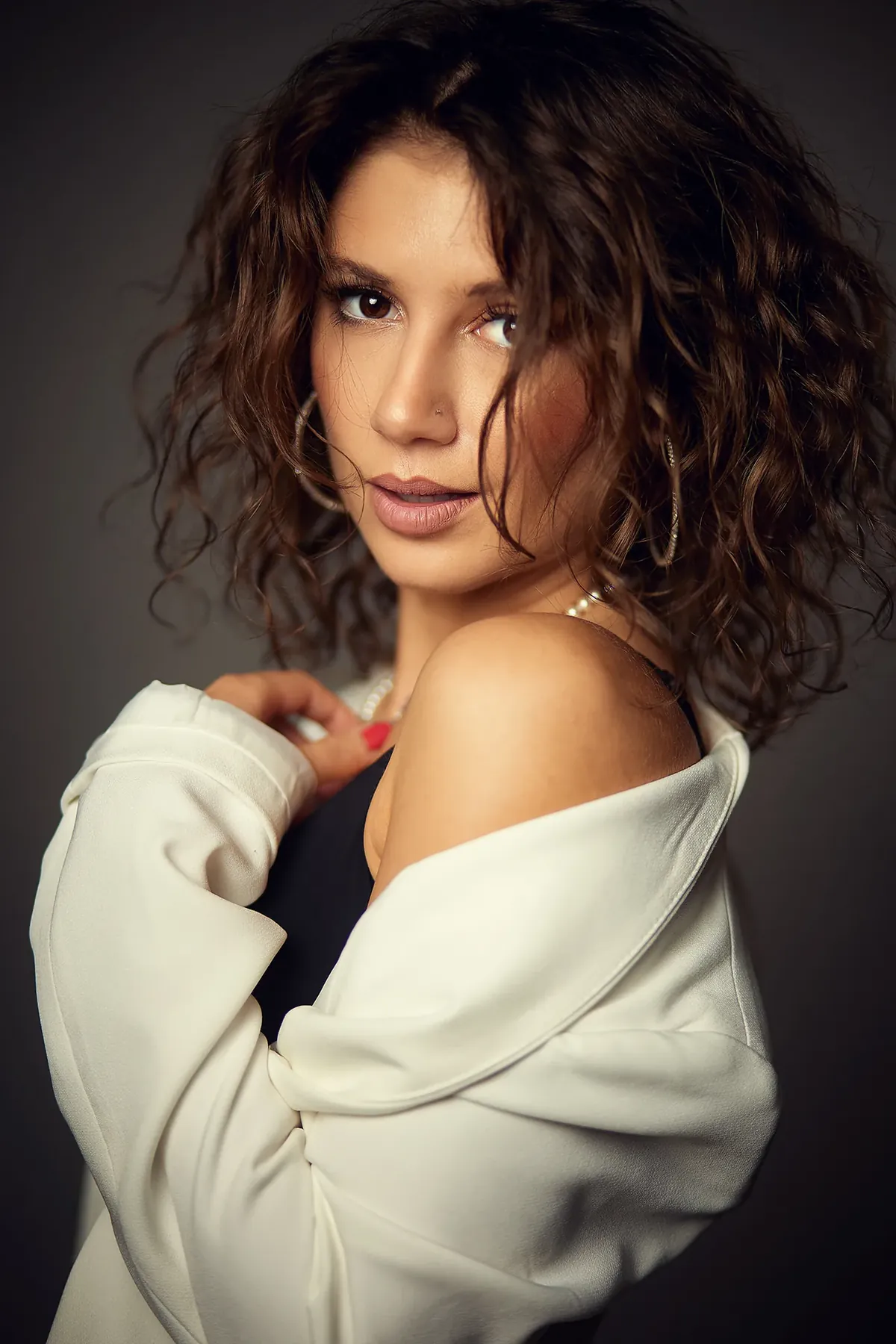 Porträt einer Frau mit Locken und weißer Strickjacke