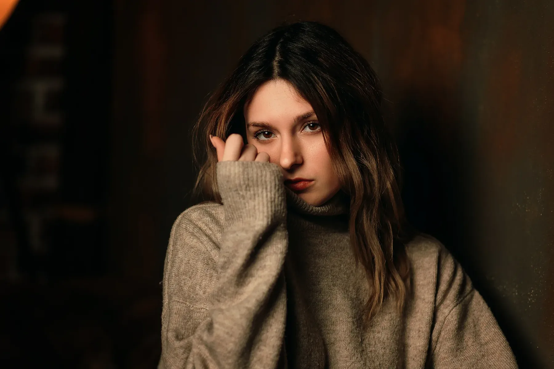 Portrait of a woman with a fringe in a grey knitted jumper